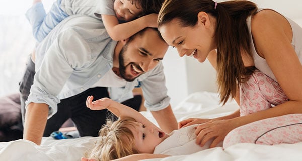 Family of four roughhousing with each other Family of four roughhousing with each other