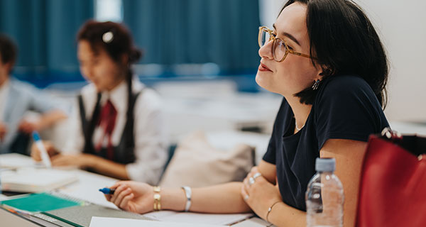A student sits in class and listens intently A student sits in class and listens intently